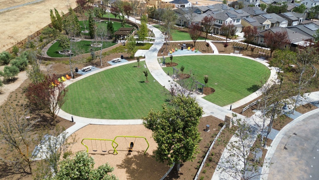 Rosie’s Greenway with swing benches, play equipment, and gathering places flanks the community dog park